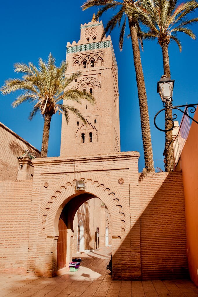 Stunning view of the Koutoubia Mosque in Marrakech with palm trees and clear skies.